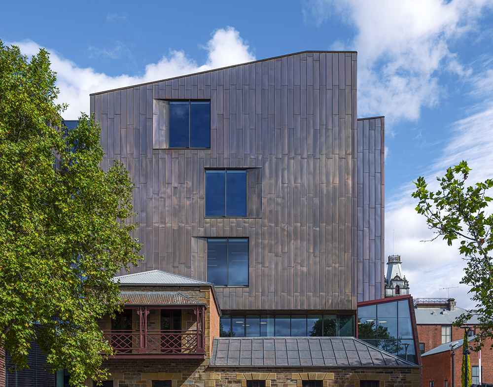 The copper clad Bendigo law Courts exterior is set amongst trees, in front of a blue sky.