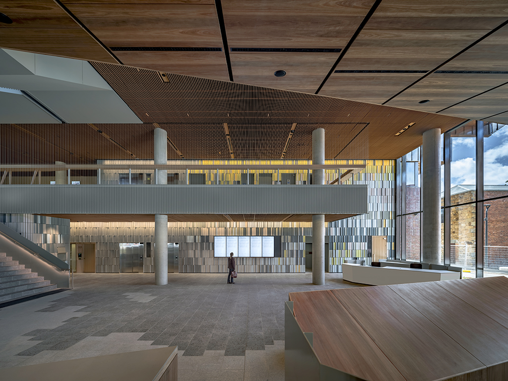 An image shows a large room with screens on the back wall and a person standing in front of them